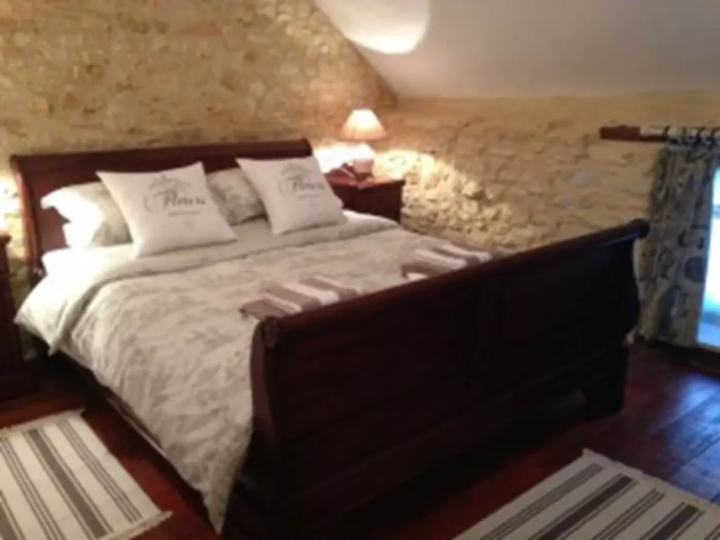 Le lit queen size et son linge blanc, sous la charpente