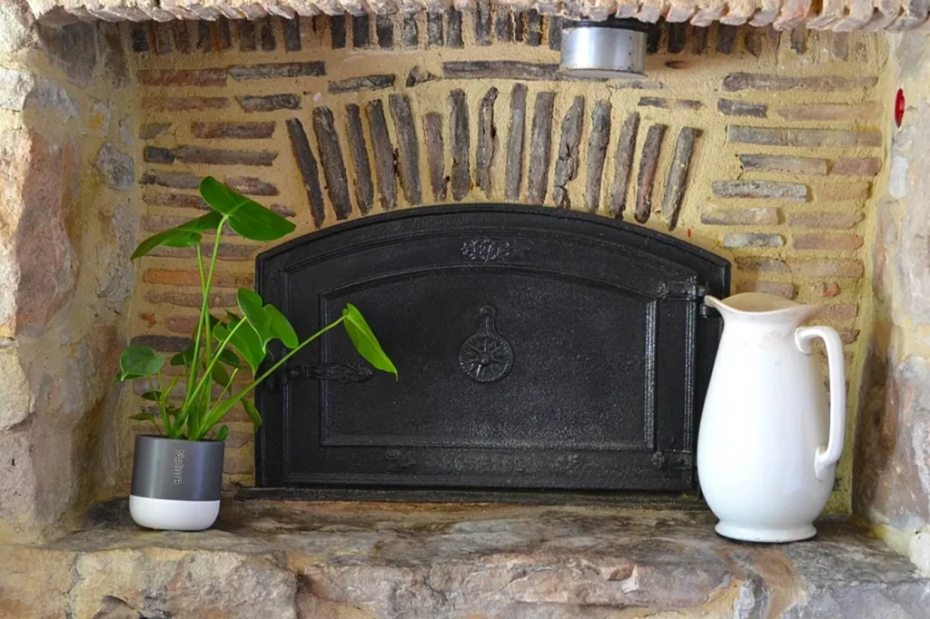 Ancien four à pain en fonte dans le mur de pierre et de brique