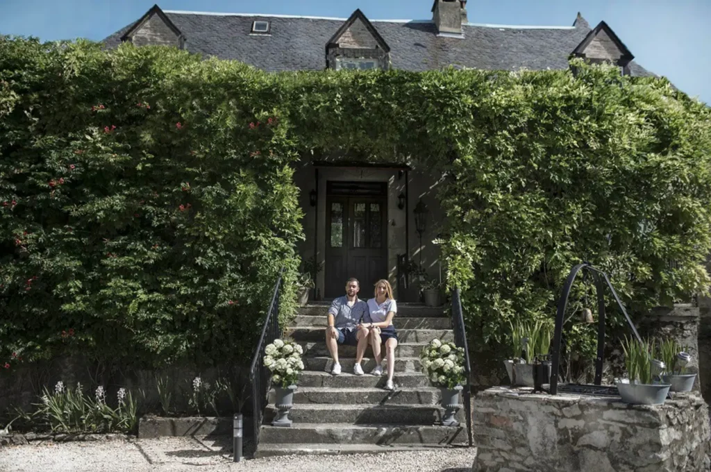 Jennifer et Kévin devant l'entrée fleurie de la maison