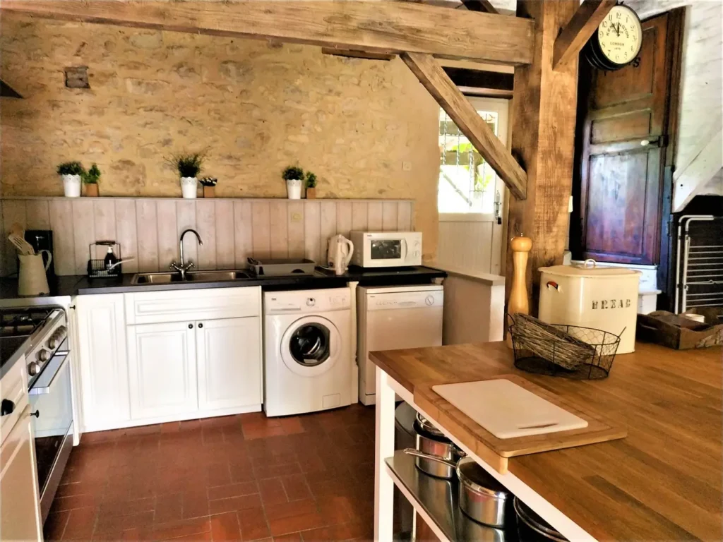 Cuisine équipée : plaques, lave-linge et plan de travail en bois