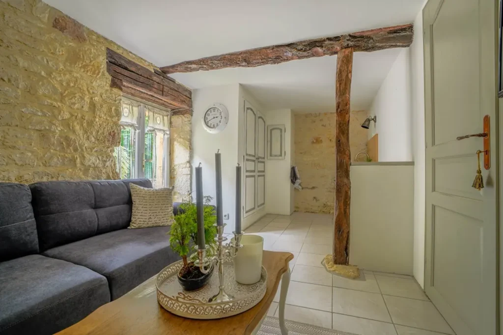 Wohnzimmer von La Suite: graues Sofa und Couchtisch, Kochnische im Hintergrund