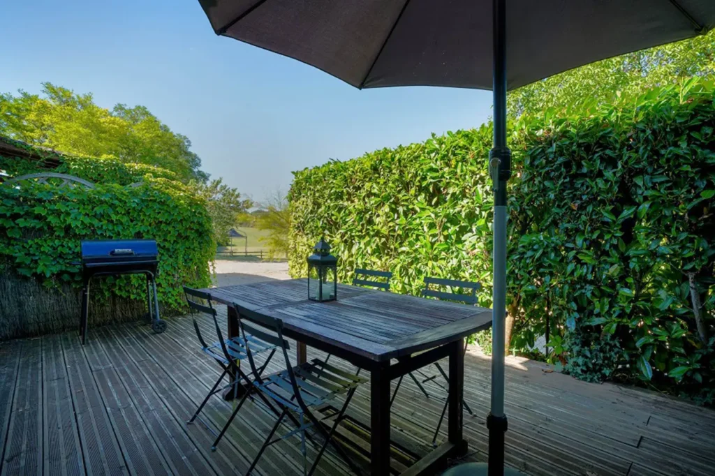 Terrasse en bois avec table, chaises et parasol