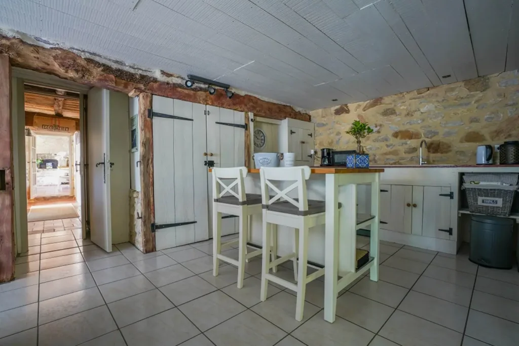 Cuisine équipée avec îlot et tabourets blancs